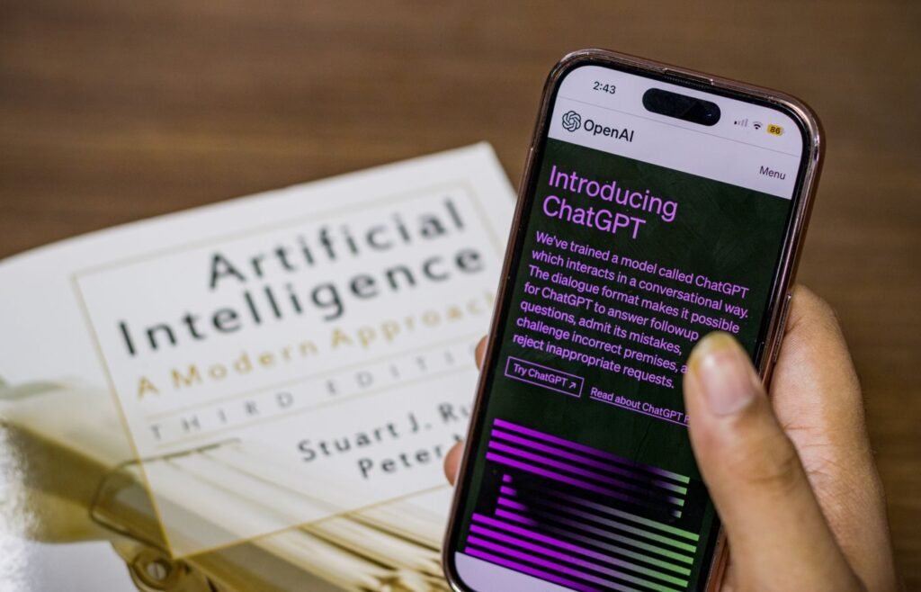 Smartphone displaying an AI chat assistant resting on a book about artificial intelligence