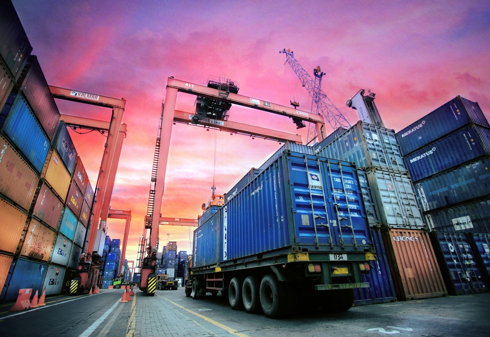 Shipping containers stacked at a port at sunset