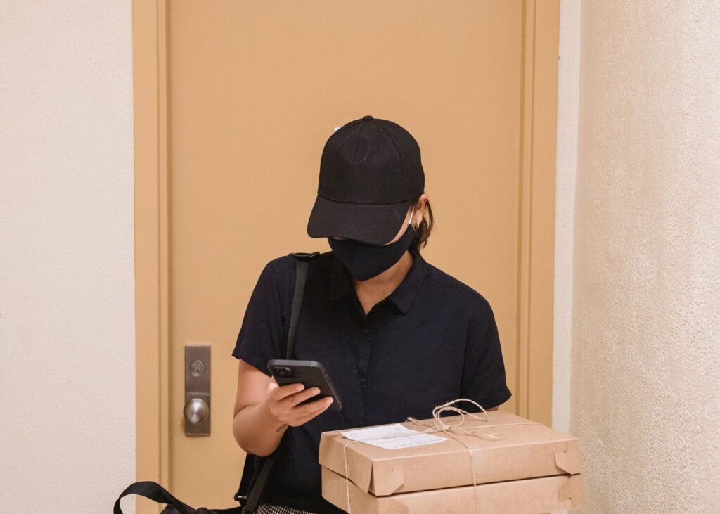 Courier delivering packages in an apartment hallway