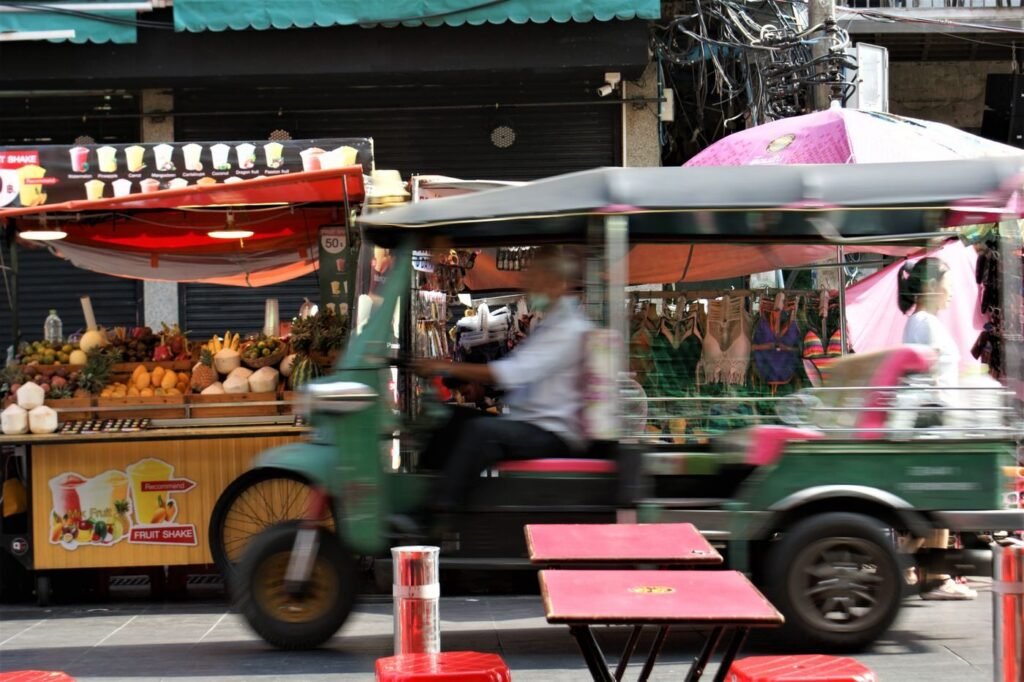Auto rickshaw moving through a South Asian market street