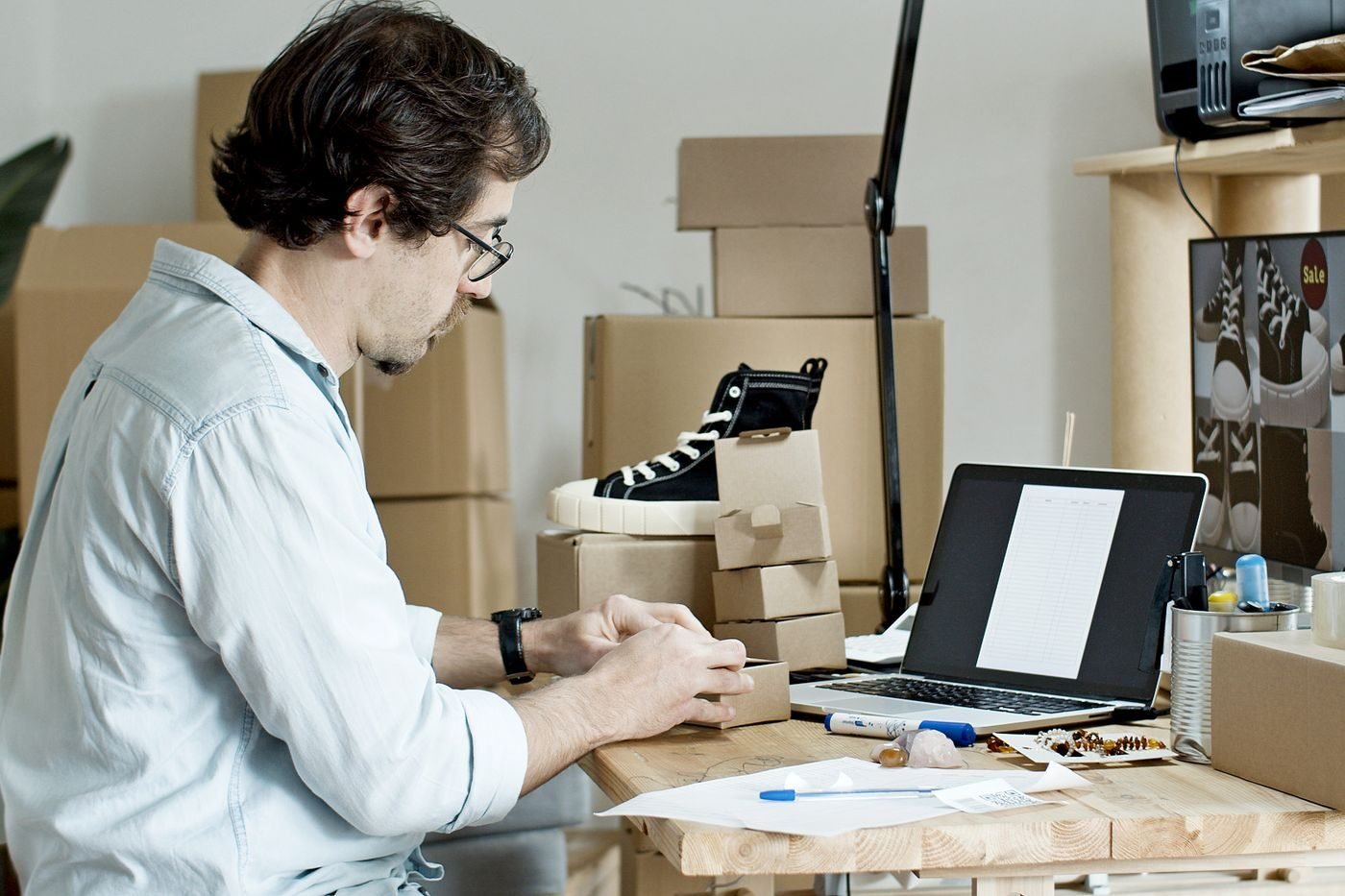 Business owner packing online orders at a desk with a laptop
