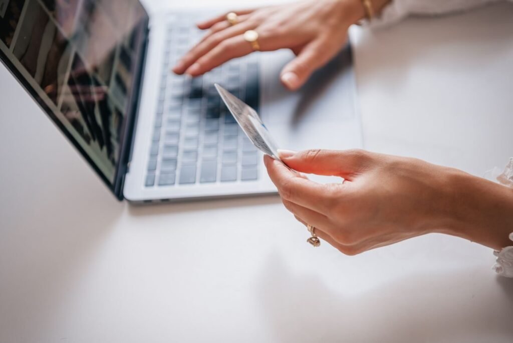 Close-up of a shopper typing on a laptop holding a payment card