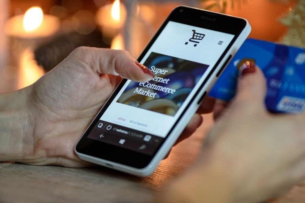 Shopper using a smartphone while holding a payment card