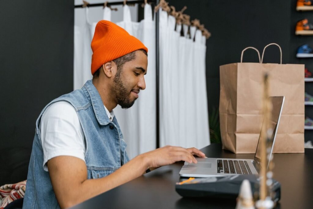 Shopper using a store on a laptop while a merchandiser reviews the experience