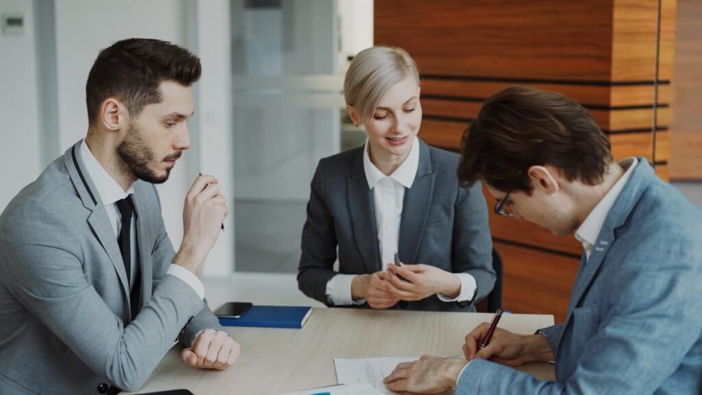 Business people signing a supply agreement at a table