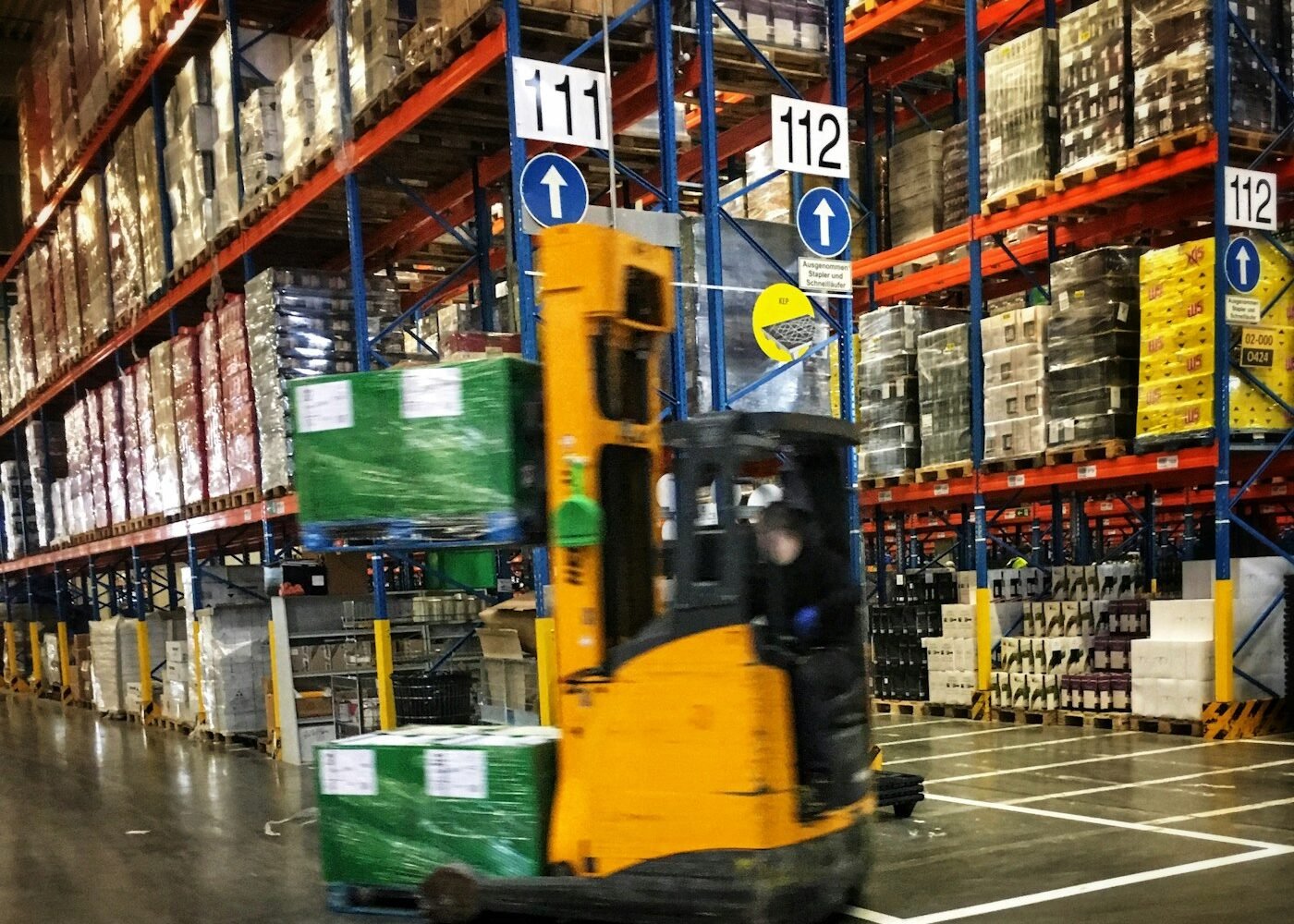 A forklift moving pallets through a distribution warehouse