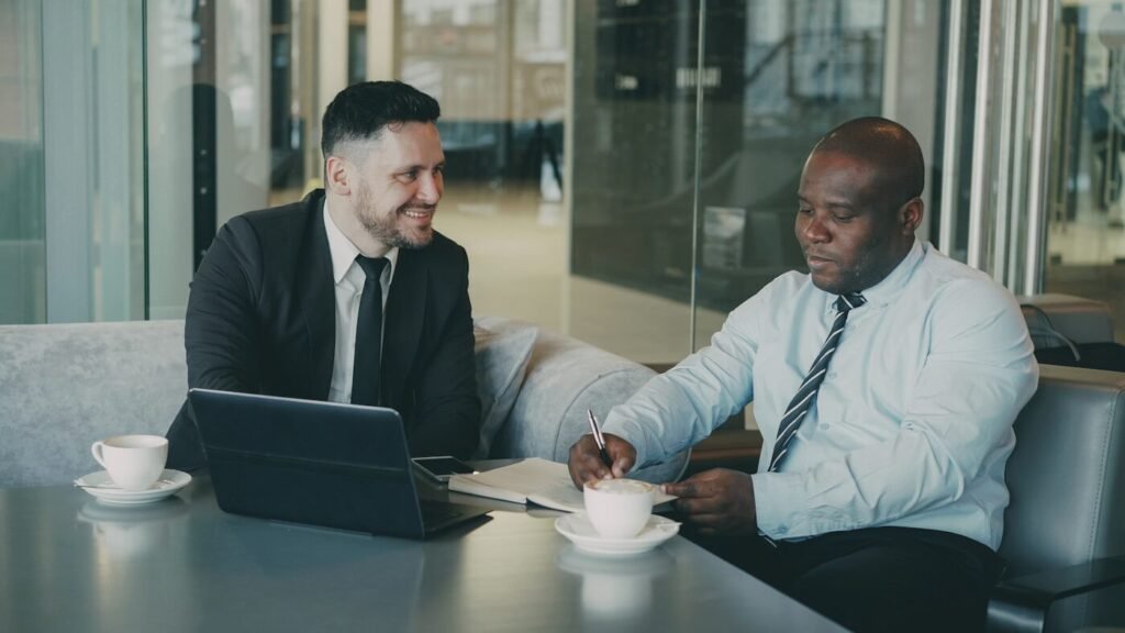 Two business buyers discussing documents over coffee