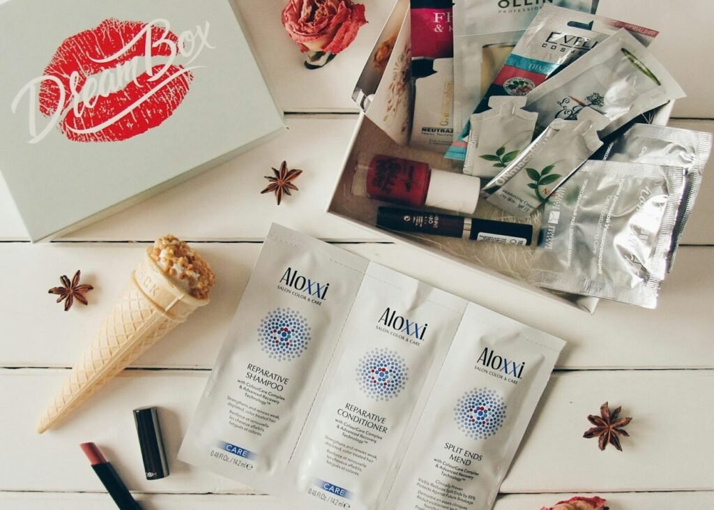Beauty products beside an open box on a white surface