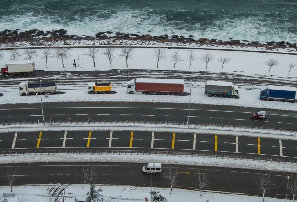 Aerial view of a highway with freight trucks crossing a vast landscape