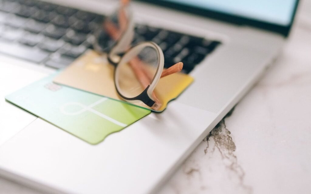 Laptop with glasses and payment cards representing an abandoned online checkout
