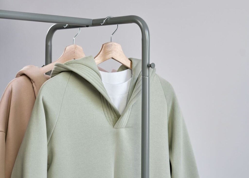Minimalist knitwear photographed on hangers in a studio