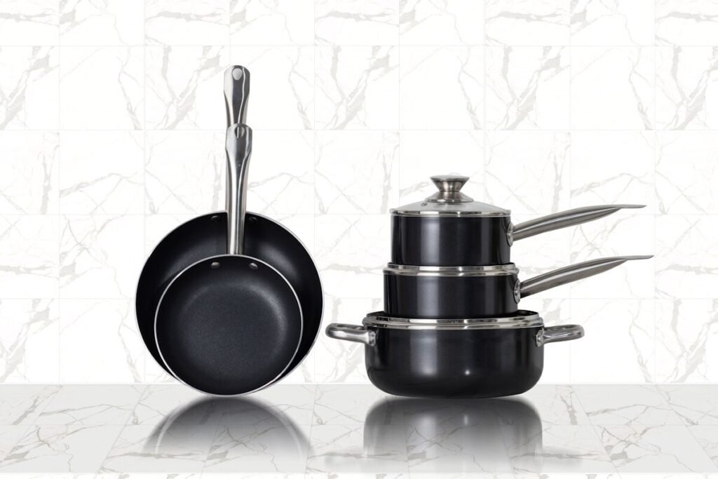 Three stainless steel pans on white tiles