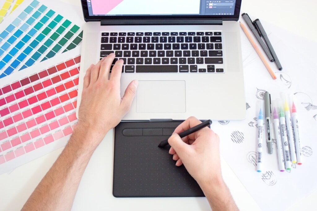 A designer working with a drawing tablet and colour swatches