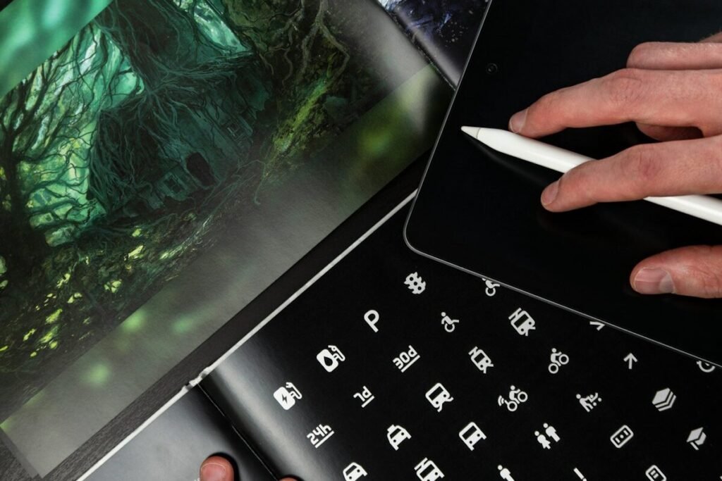 Design books open beside a tablet and stylus