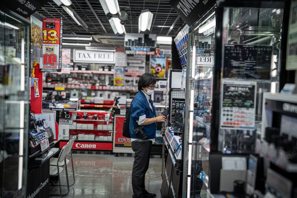A shopper browsing electronics in a brightly lit store