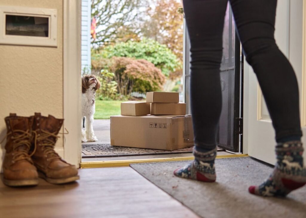 Customer opening the door to delivery boxes at home