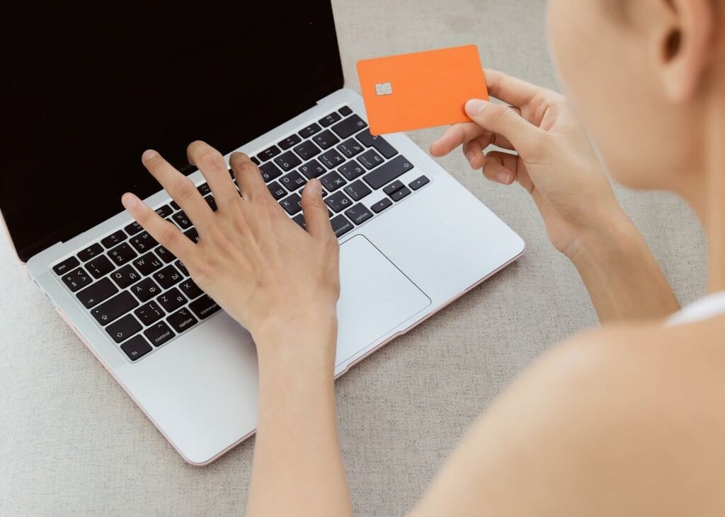 Shopper using a laptop and bank card for an online purchase