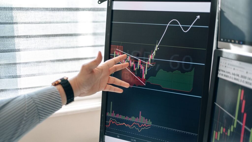 Analyst pointing at pricing and margin graphs on a monitor