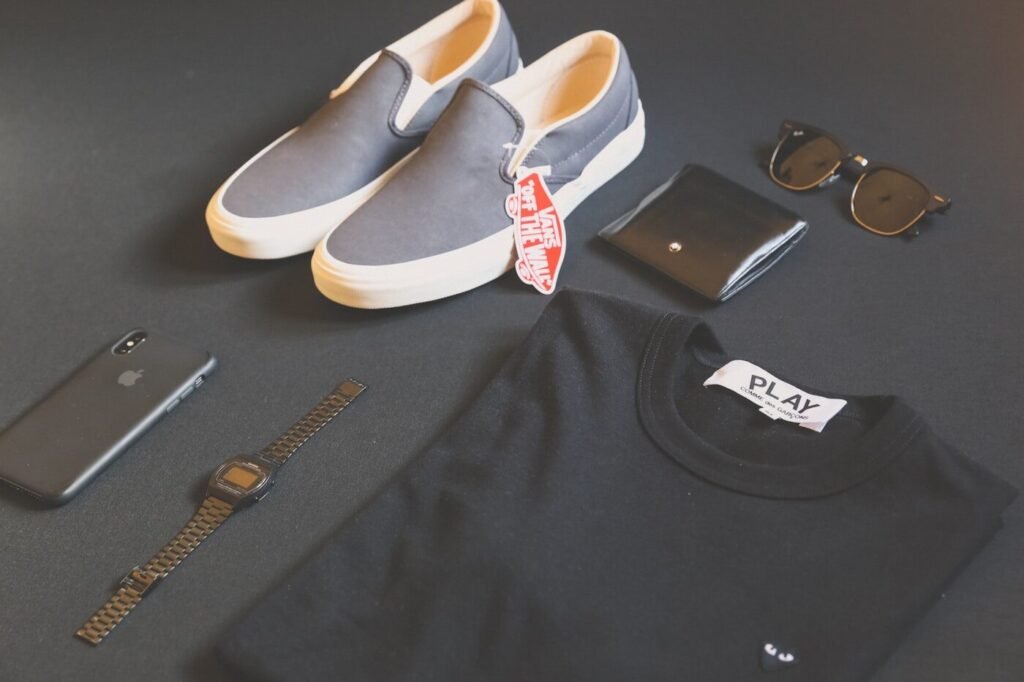 Folded shirt styled with a phone, watch and sneakers