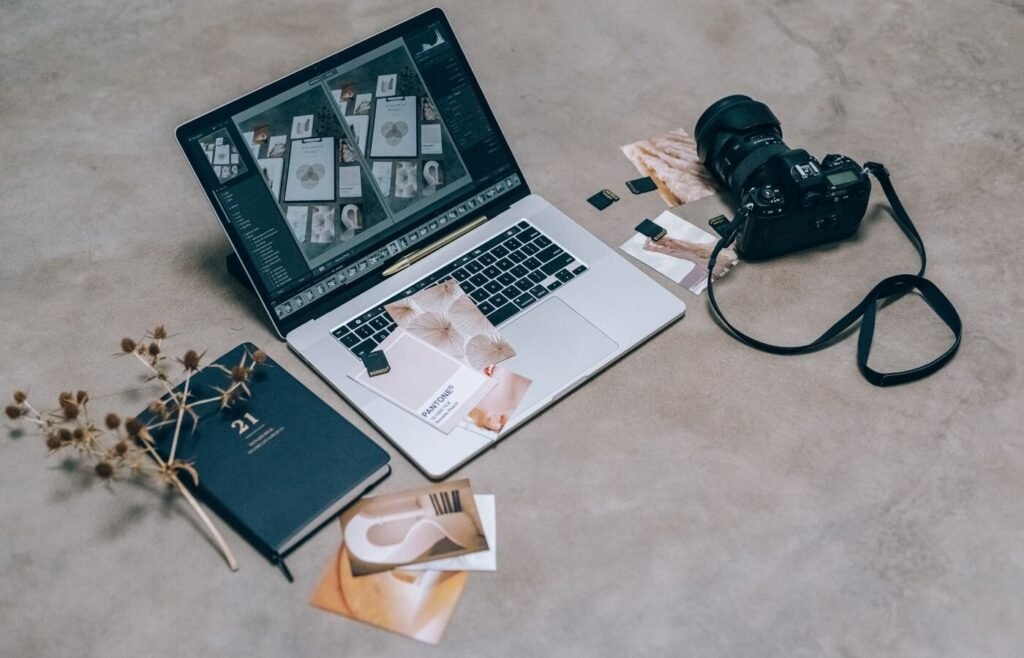 Workspace with a laptop, camera and product materials used to prepare catalogue data