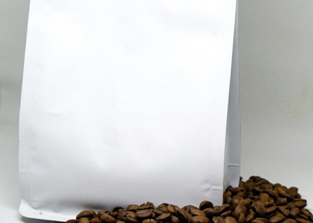 A bag of coffee beans beside loose roasted beans