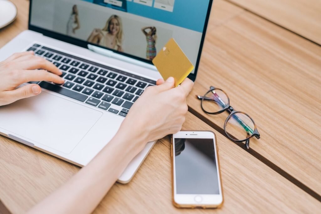 Shopper holding a payment card while buying on a phone
