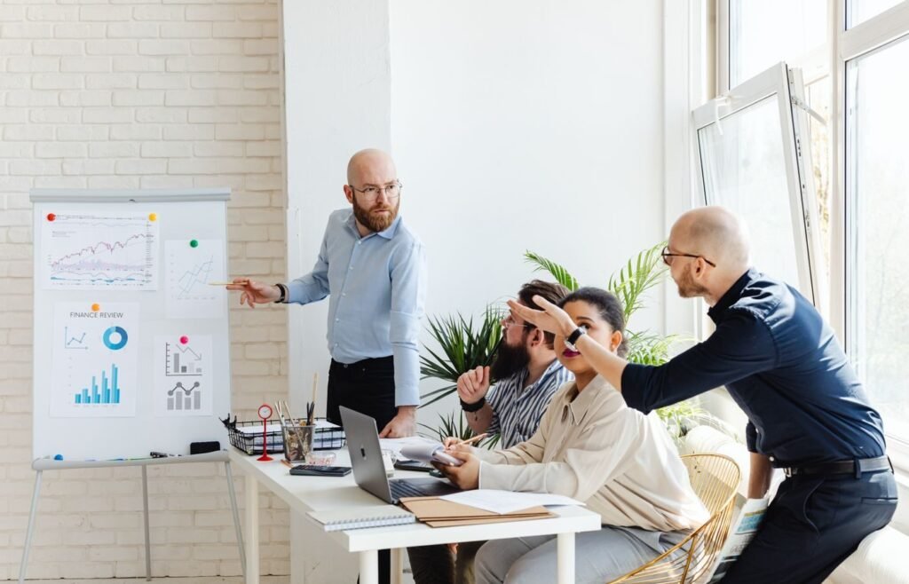 Team reviewing financial charts on a whiteboard during a monthly business review
