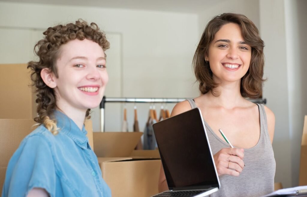 Two founders working together on an online store surrounded by boxes and a laptop
