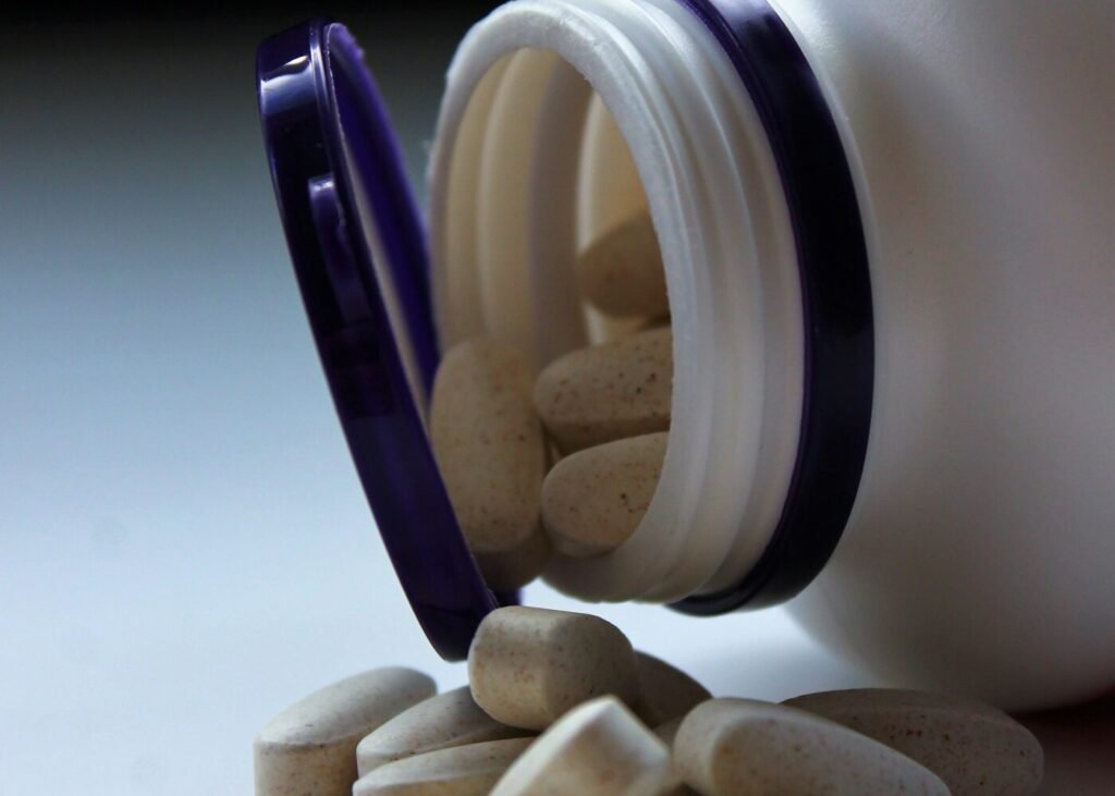 White supplement capsules on a plain surface