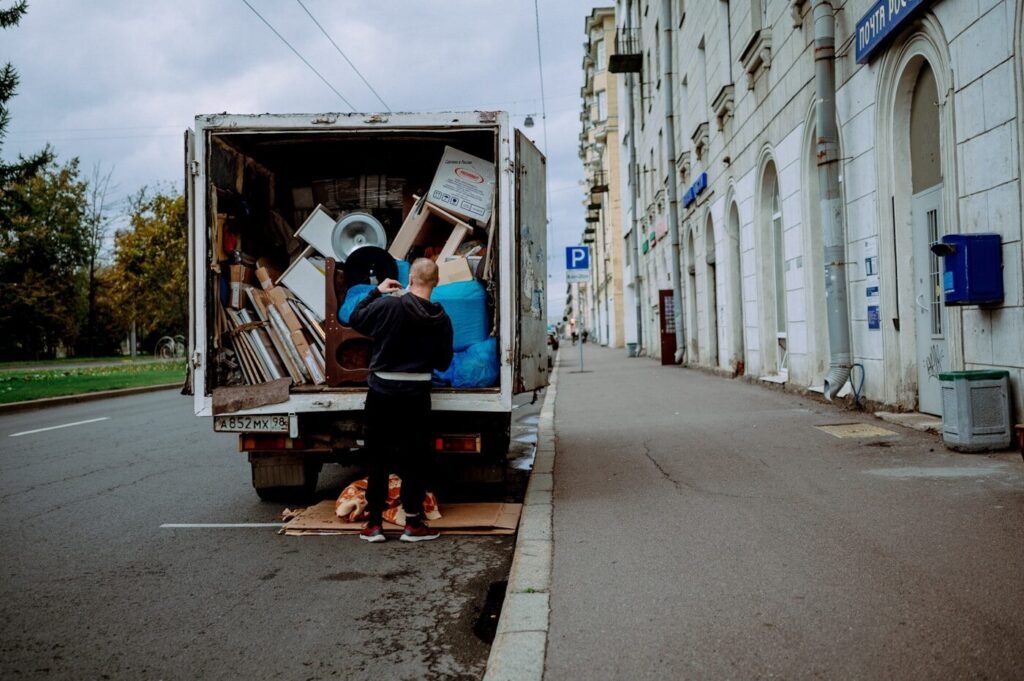 A delivery driver unloading furniture from the back of a truck