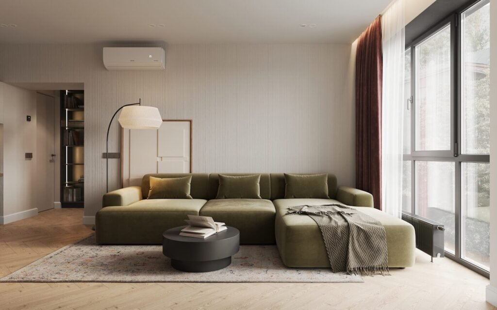 A living room arranged around a large green sofa