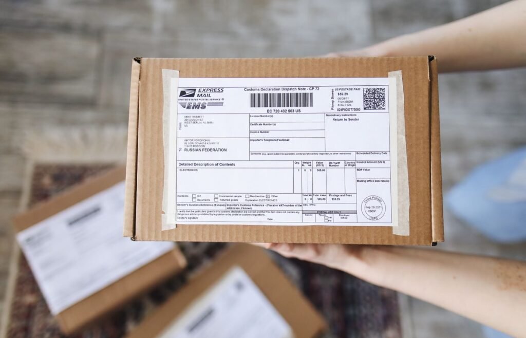 Hands holding an export parcel with a customs declaration attached