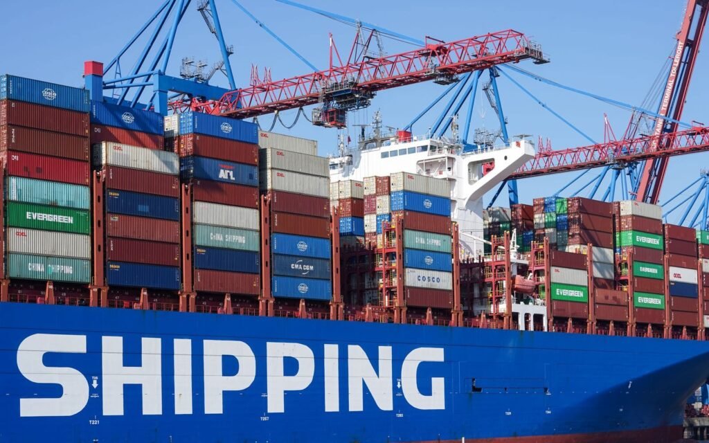 Container ship docked under port cranes, the physical reality behind cross-border eCommerce