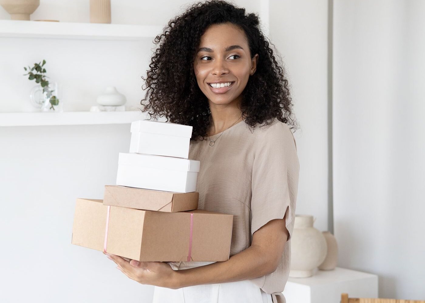Seller holding cardboard boxes of online orders ready for despatch