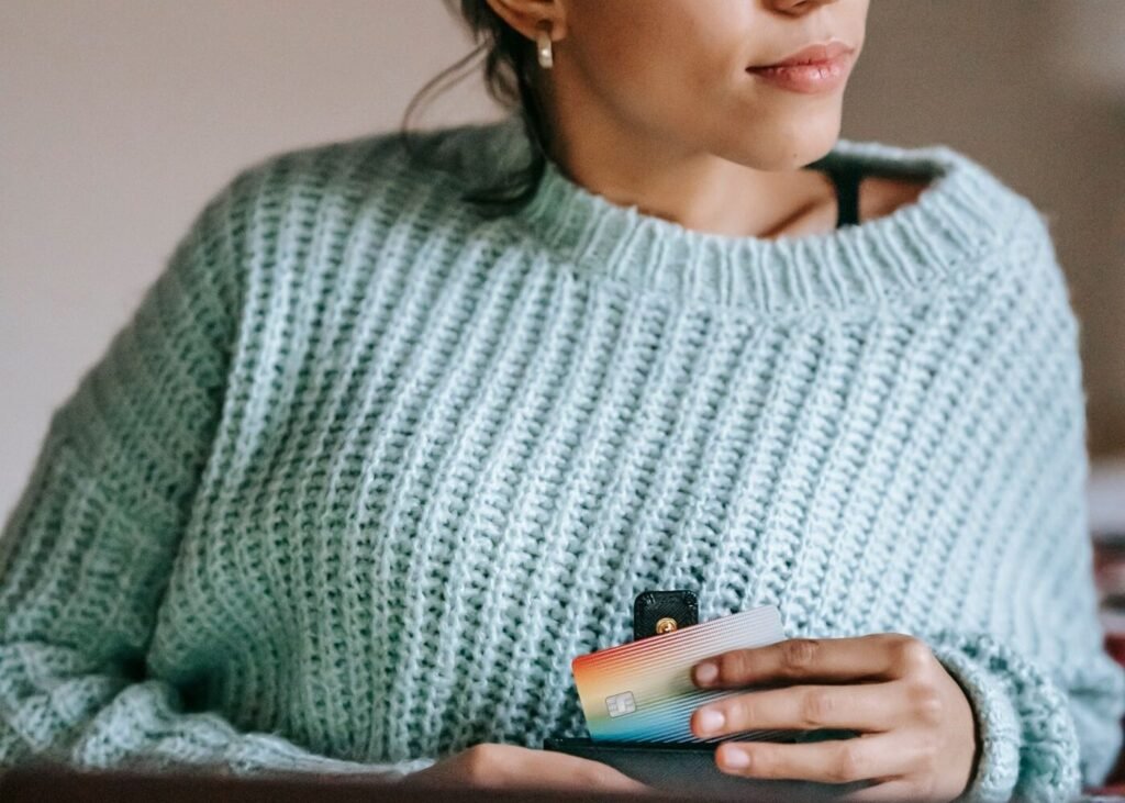 Shopper comparing products online with a debit card in hand