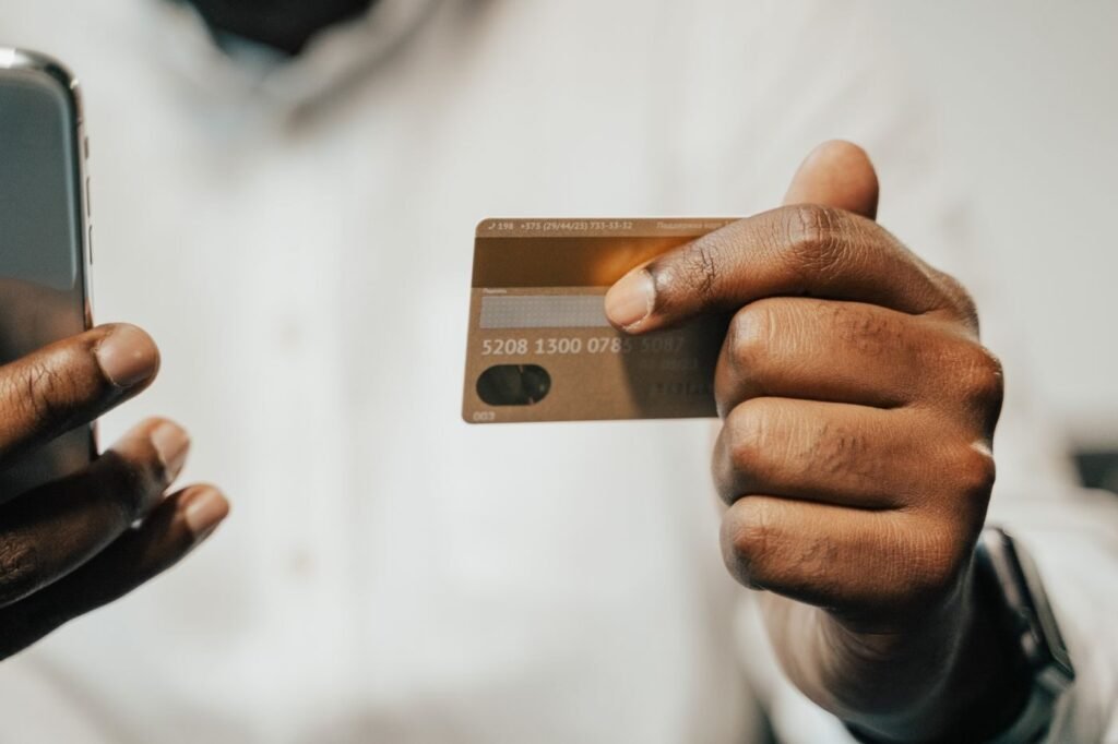 Shopper holding a payment card and a mobile phone