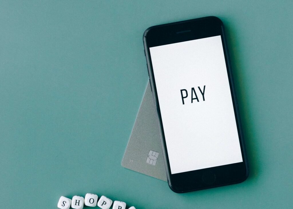 Smartphone showing a payment screen beside a bank card