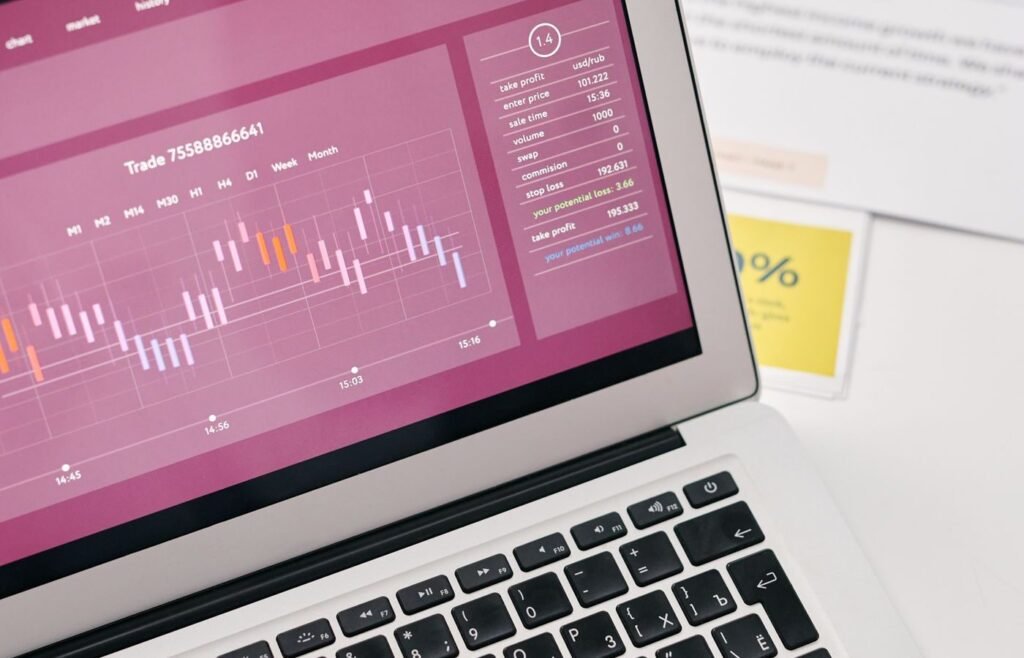 Laptop showing marketing performance graphs beside printed channel reports