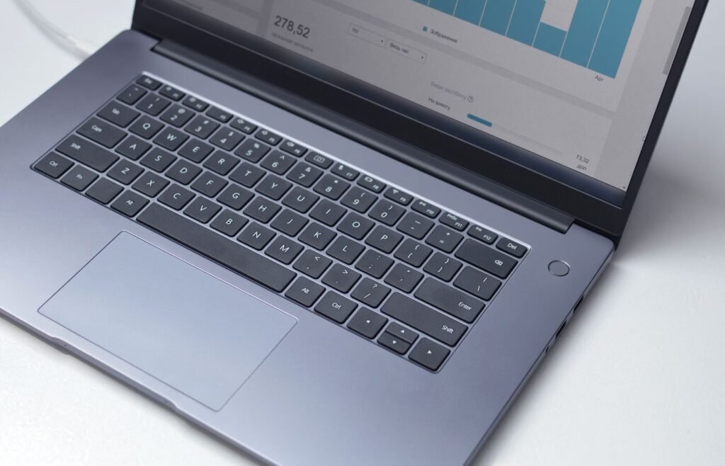 Laptop showing marketplace performance analytics on a white desk