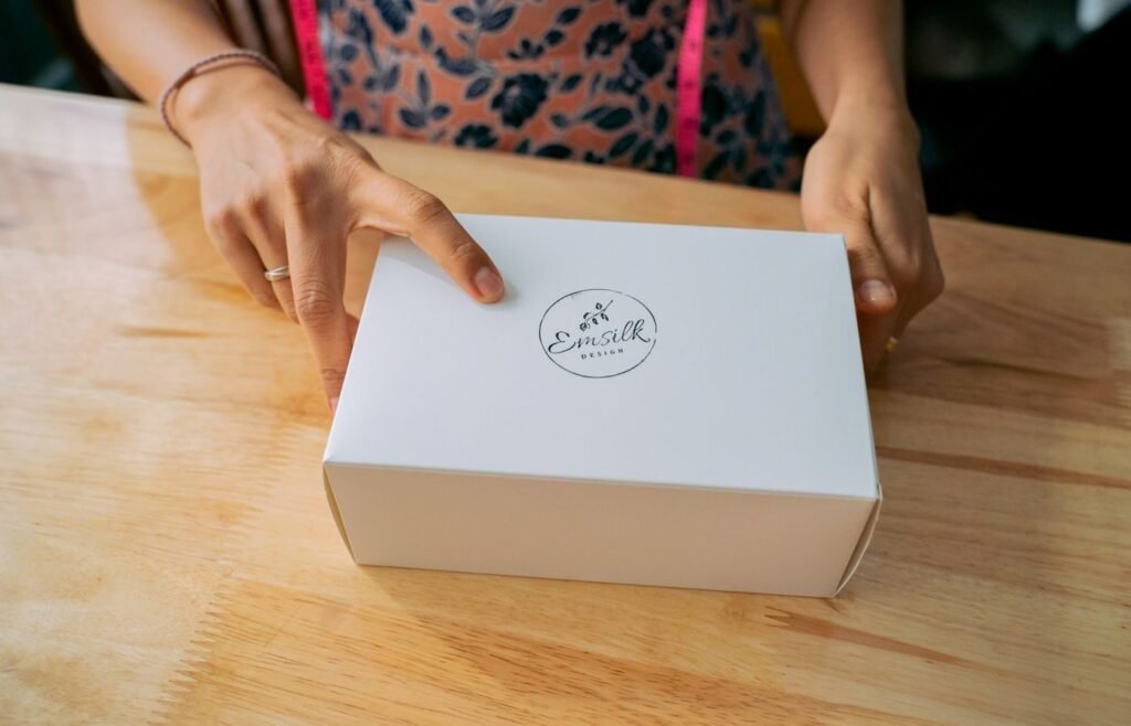 Hands holding a branded delivery box, the unboxing moment that sets up a second order