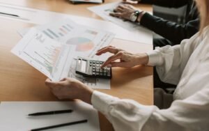 Hands working through margin calculations with charts and a calculator