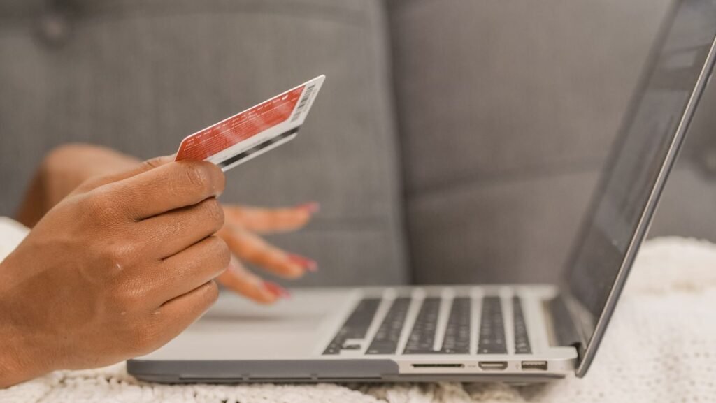Shopper holding a card while ordering online, the transaction a revenue forecast is built from
