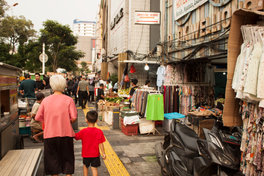 Busy street market with shoppers and stalls in Southeast Asia