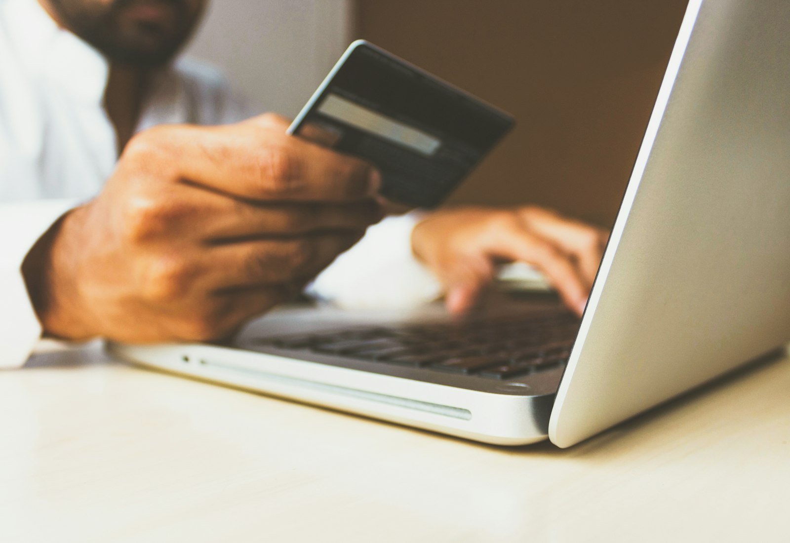 Person shopping online with a laptop and payment card
