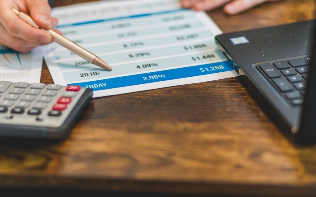 Working through acquisition cost figures on paper with a calculator and pen
