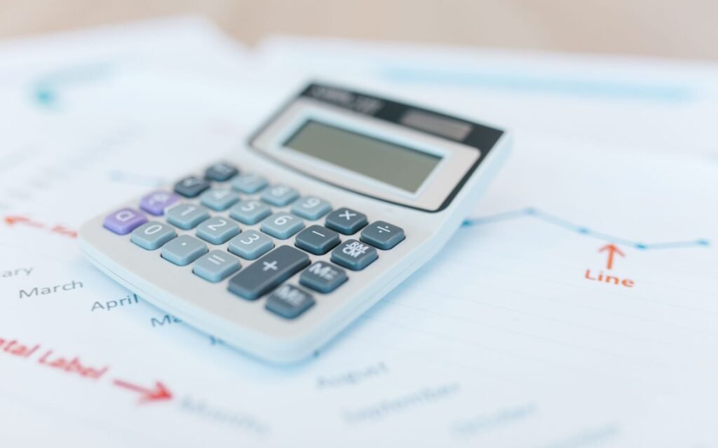 Calculator resting on a campaign performance report, working out marketing return on investment