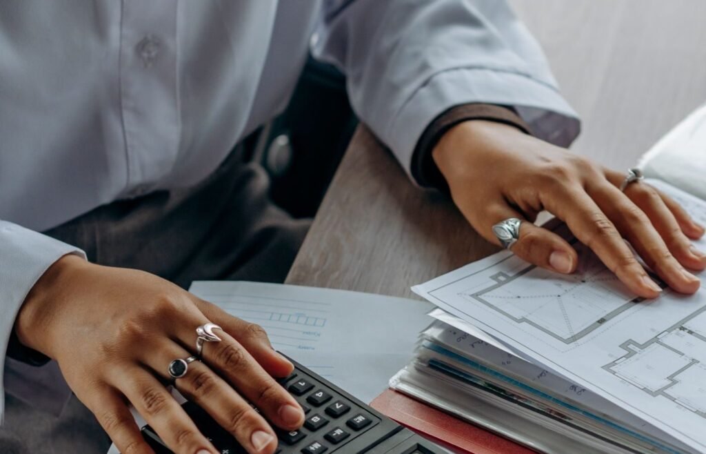 Accountant working through repeat purchase figures with a calculator and documents
