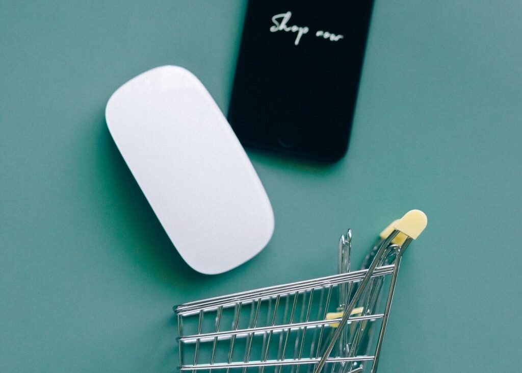 Smartphone beside a miniature shopping trolley representing a brand own online store