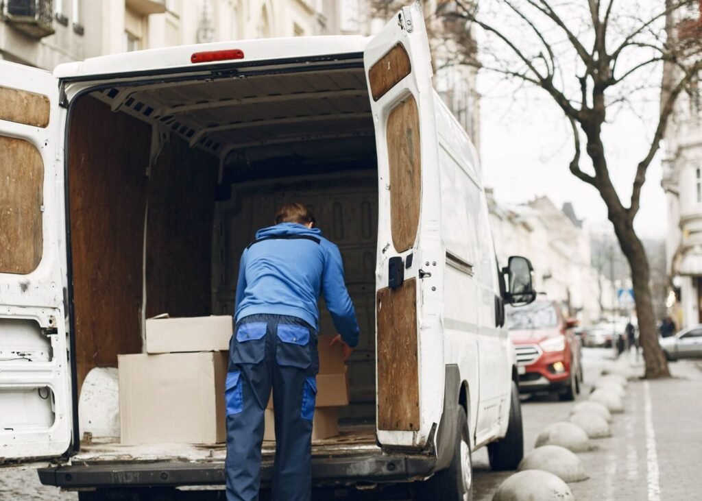 Worker loading boxes into a delivery truck for export