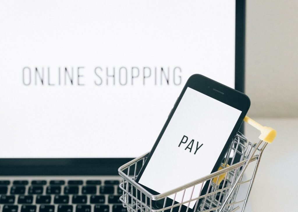 Miniature shopping cart beside a laptop representing a direct-to-consumer online store